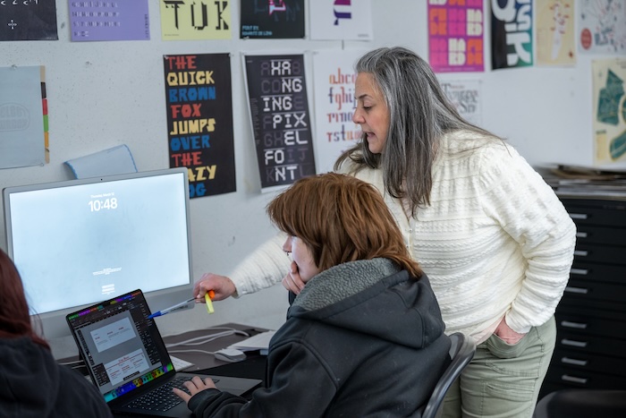 teacher showing graphic design computer tip