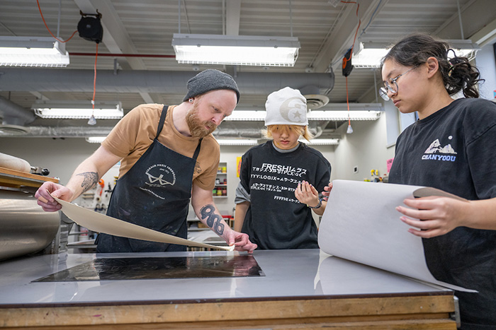 teacher instructs printmaking class