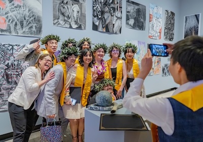 commencement group student picture posing in front of art works